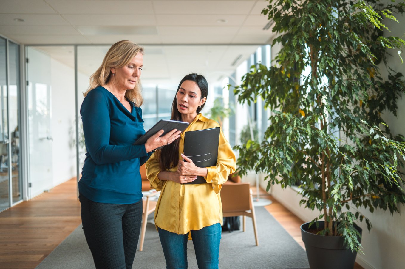 Caucasian Female Executive Instructing Her Asian Assistant